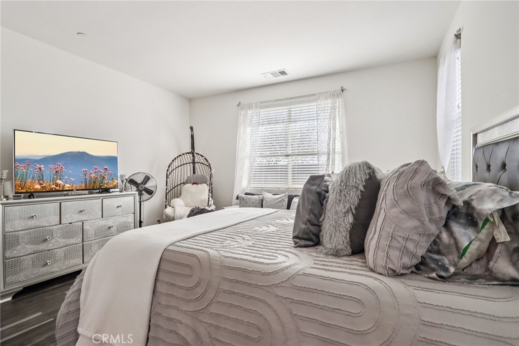 45643 Sancroft Avenue Lancaster, CA 93535 - Photo 10 of 18 a bedroom with a bed and a painting on the wall