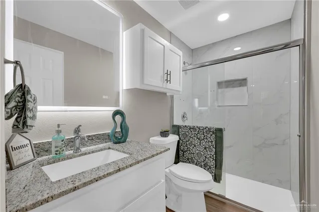 a bathroom with a granite countertop sink and white cabinets