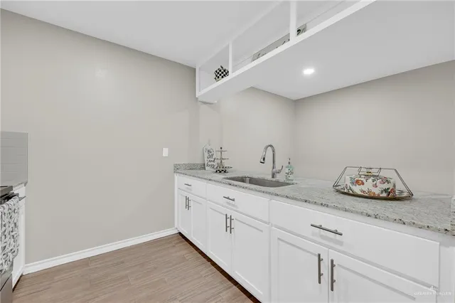 a kitchen with granite countertop white cabinets and stainless steel appliances