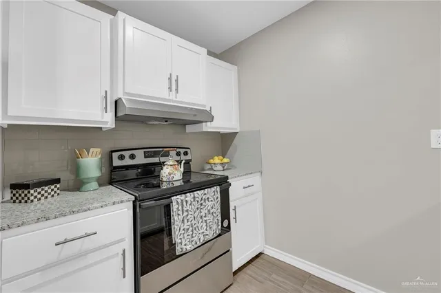 a bathroom with a granite countertop sink and white cabinets