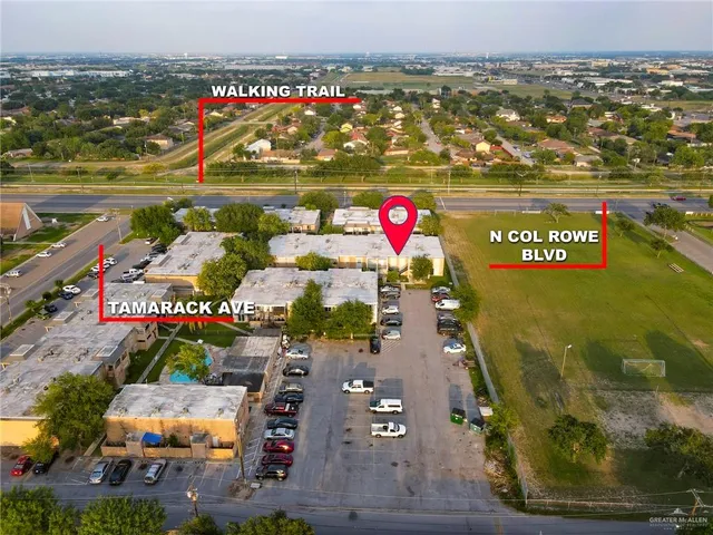 a view of a house with a yard and large tree