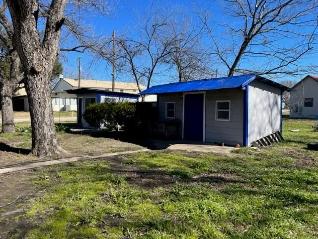 a backyard of a house with dishwasher and wooden fence