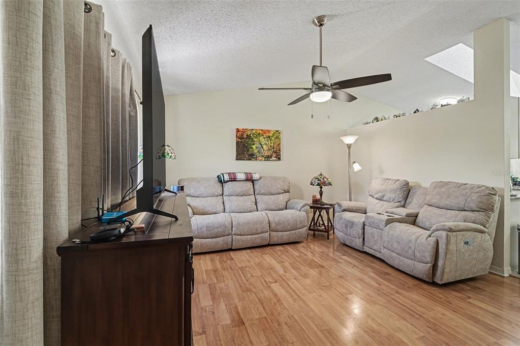 12435 Orangewood Circle Tavares, FL 32778 - Photo 6 of 30 a living room with furniture a large window and a flat screen tv