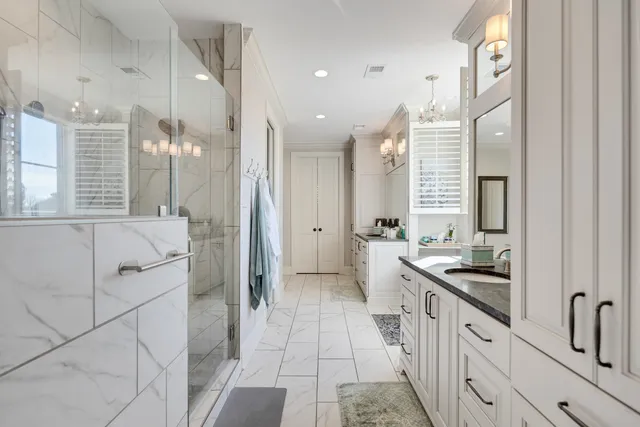 a bathroom with a granite countertop sink a toilet a mirror and shower