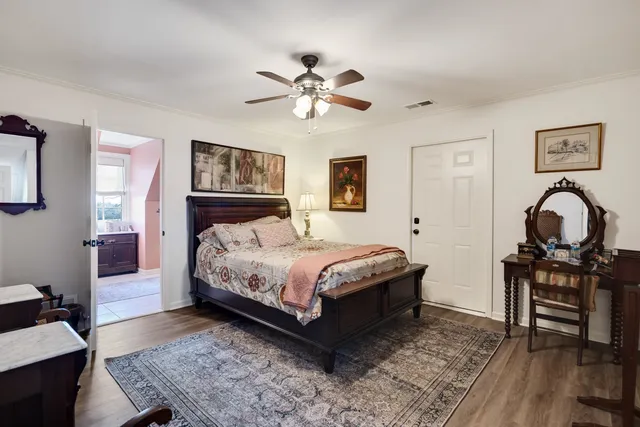 a bedroom with a bed wooden floor and a desk