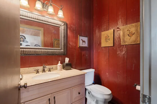 a bathroom with a sink mirror vanity and toilet