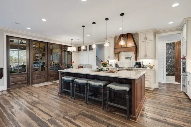 a kitchen with kitchen island granite countertop a sink counter and a living room view