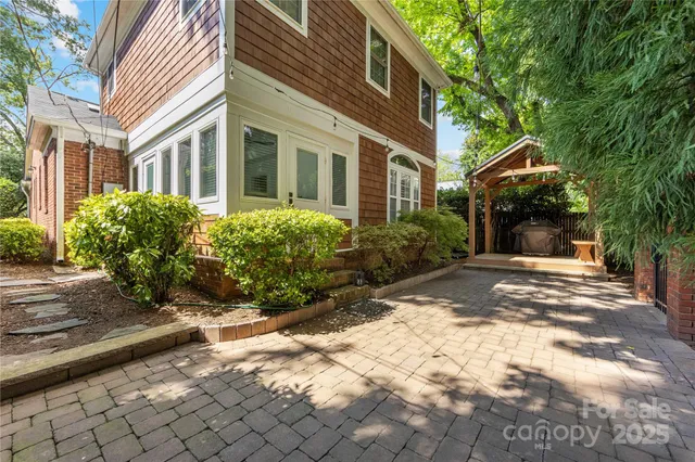 a view of a house with a tree and pathway