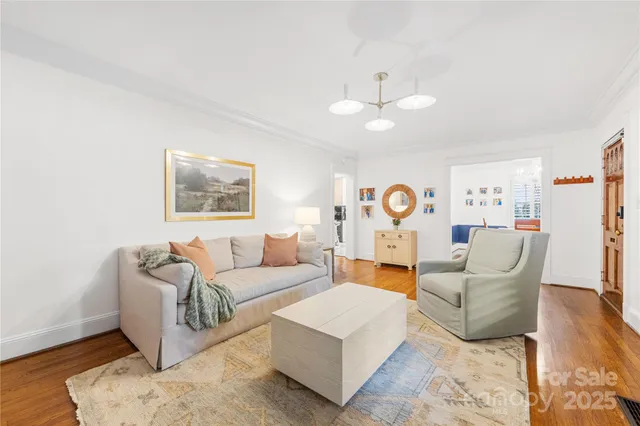 a living room with furniture and a chandelier