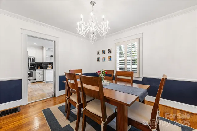 a view of a dining room with furniture a chandelier and wooden floor