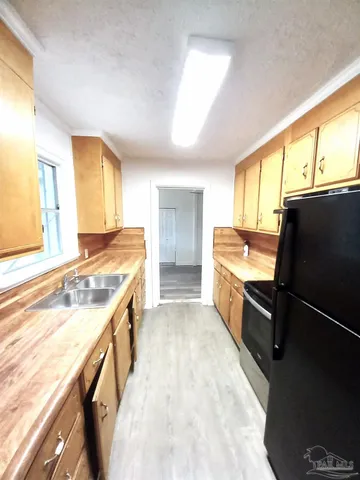 a kitchen with a stove a sink and a refrigerator