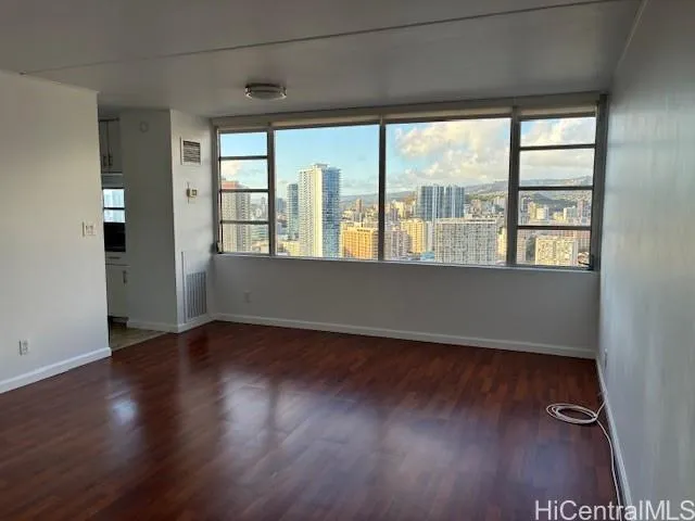 an empty room with wooden floor and windows