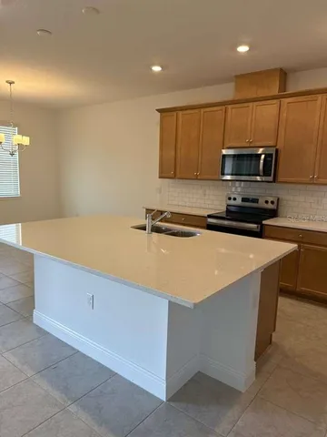 a kitchen with stainless steel appliances granite countertop a stove a sink and a microwave