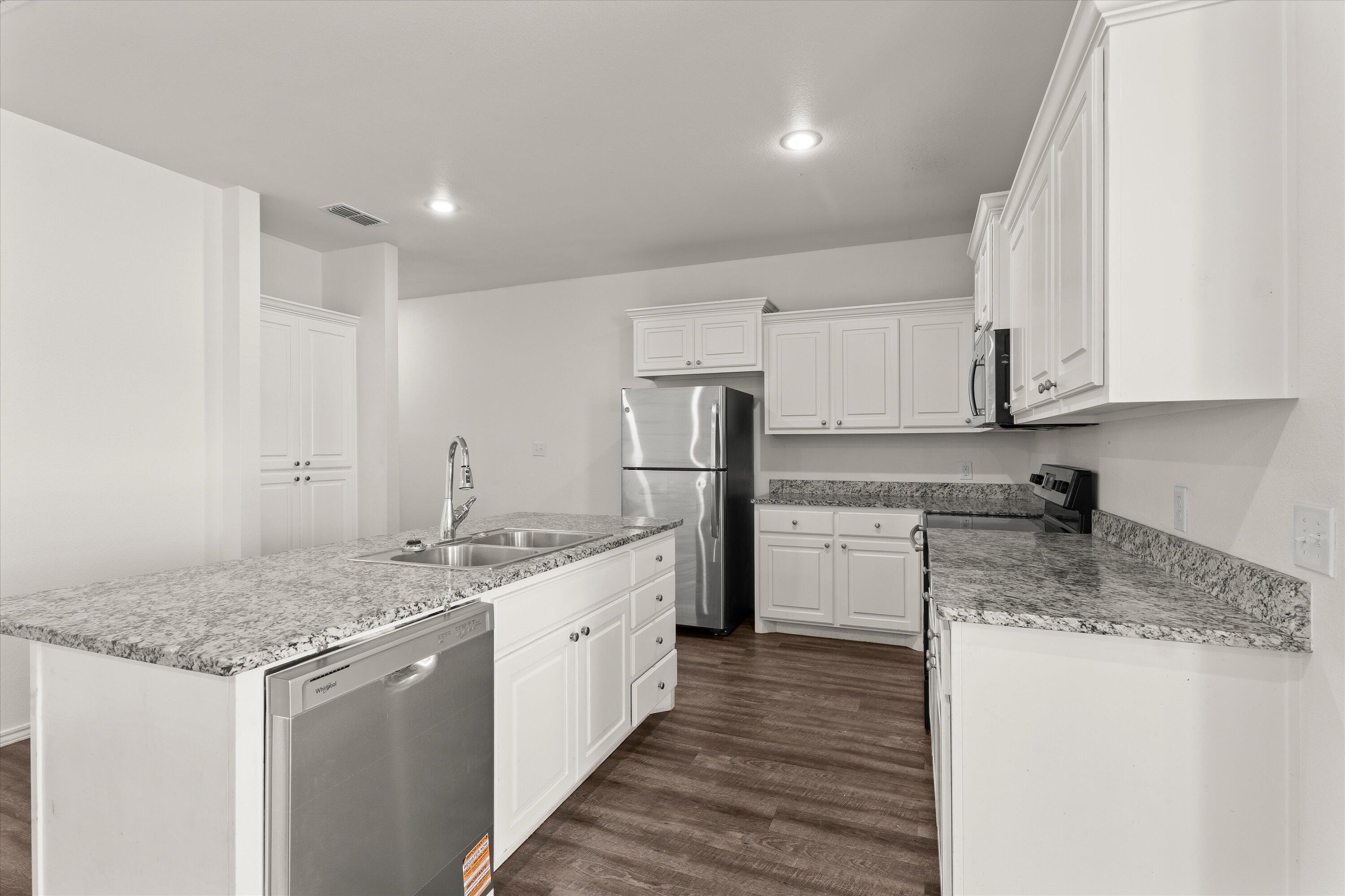 6908 21st Street Lubbock, TX 79407 - Photo 11 of 28 a kitchen that has a lot of white cabinets and stainless steel appliances