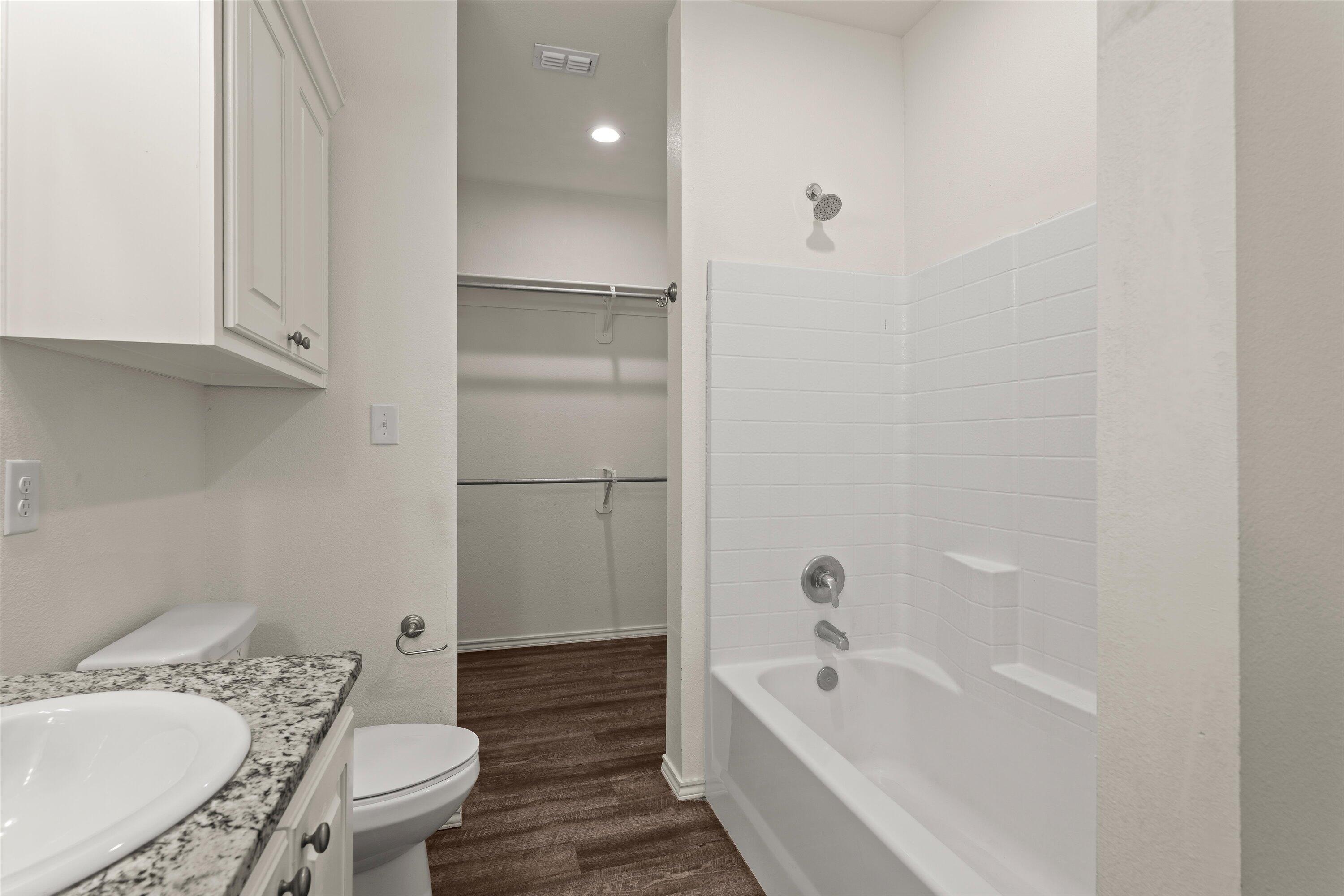 6908 21st Street Lubbock, TX 79407 - Photo 17 of 28 a bathroom with a tub a sink and a toilet