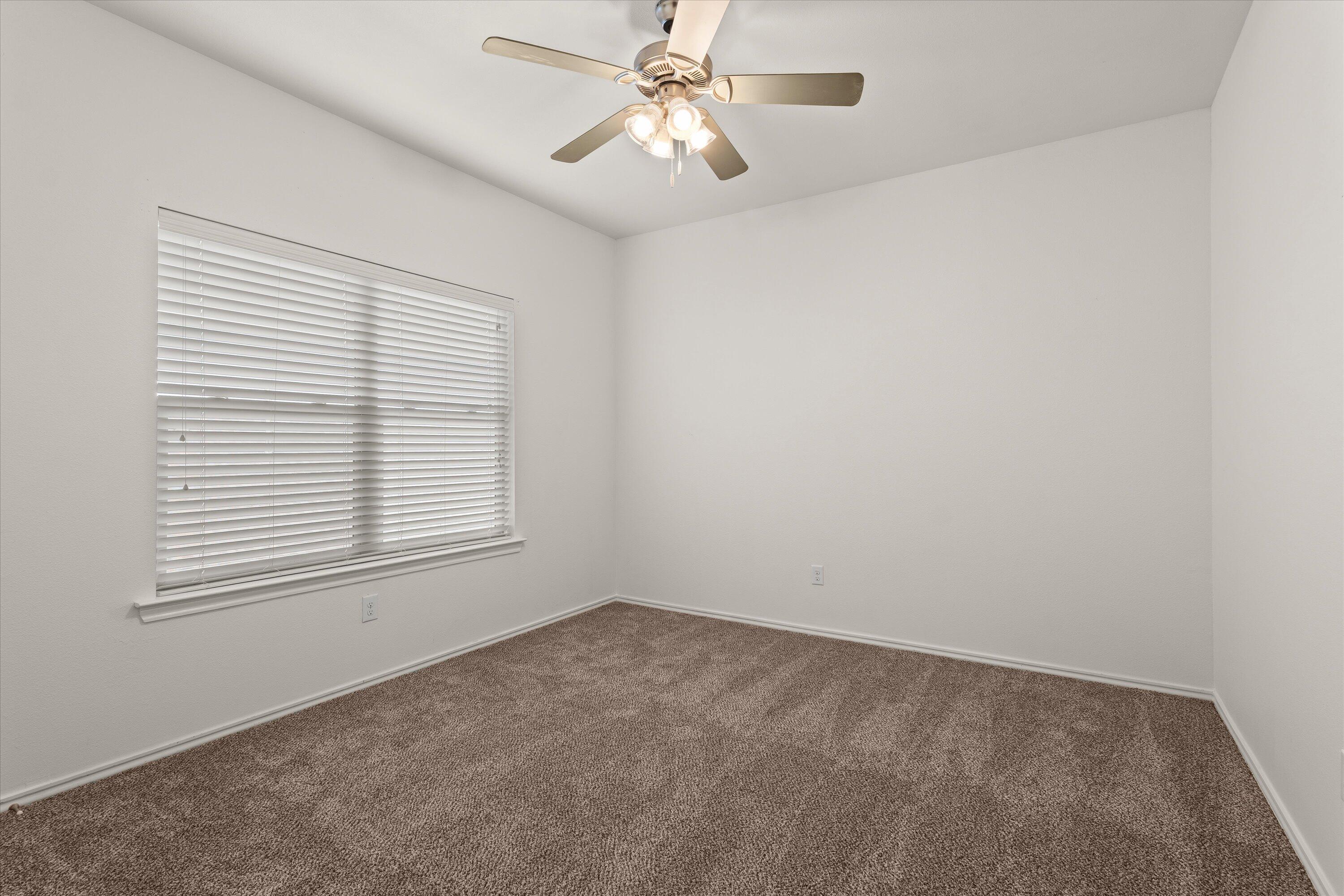 6908 21st Street Lubbock, TX 79407 - Photo 23 of 28 an empty room with a window and a fan