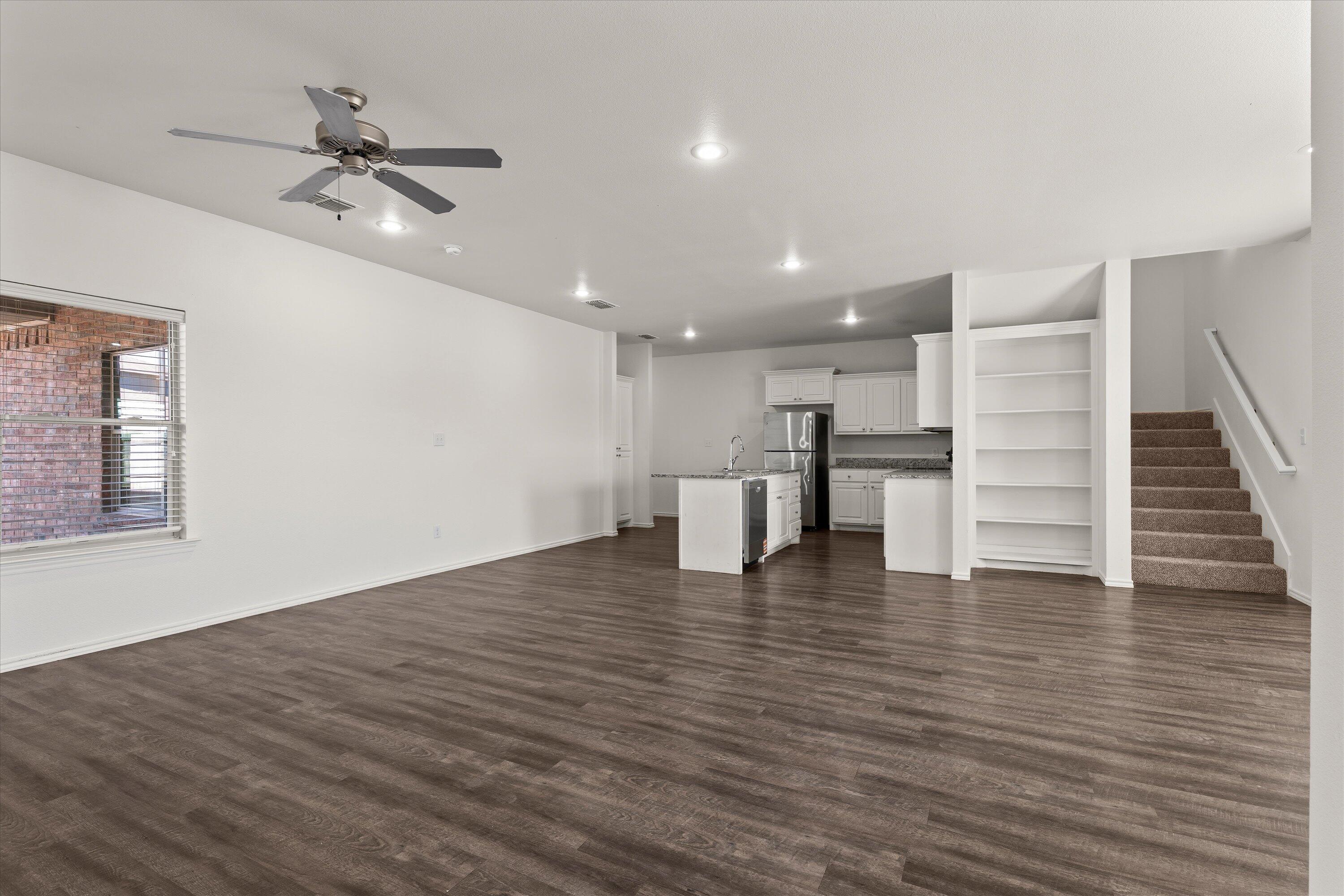 6908 21st Street Lubbock, TX 79407 - Photo 4 of 28 a view of empty room with wooden floor and ceiling fan