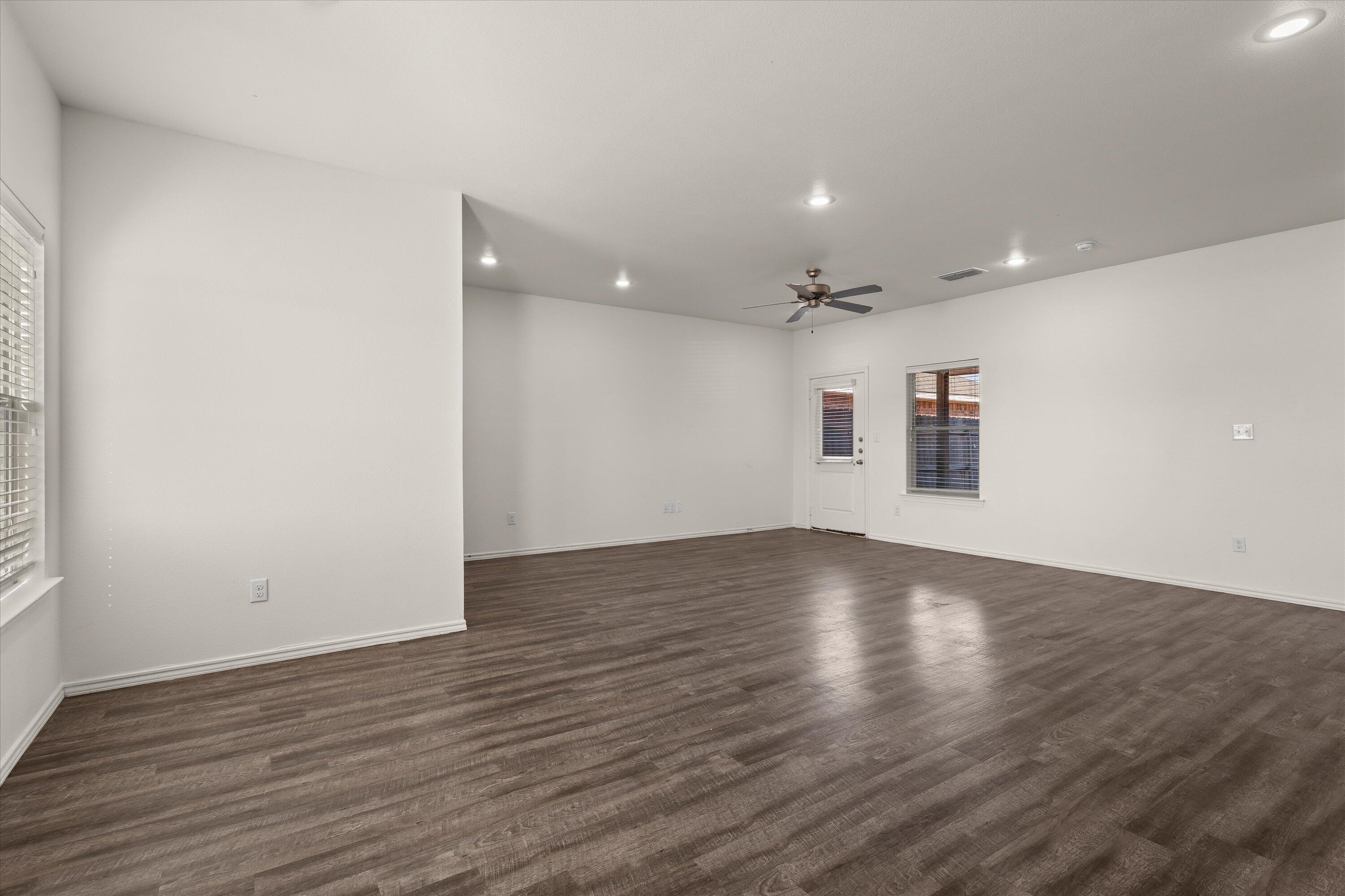 6908 21st Street Lubbock, TX 79407 - Photo 7 of 28 a view of a room with wooden floors and white walls
