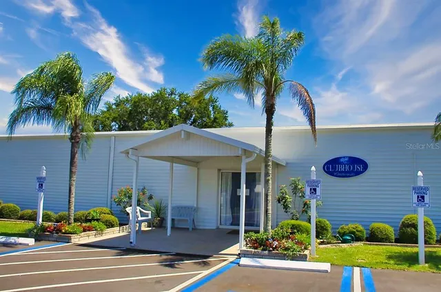 a view of a house with a yard and potted plants