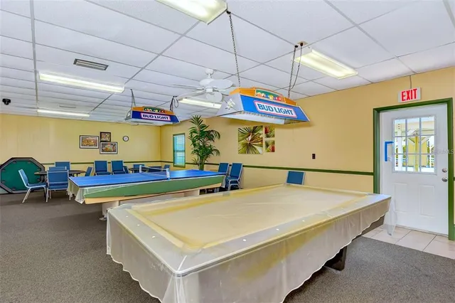 a room with pool table and windows