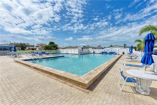 a view of swimming pool with outdoor seating and plants