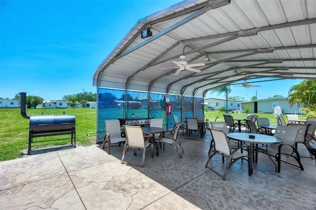 a view of a patio with table and chairs potted plants with a barbeque grill and plants