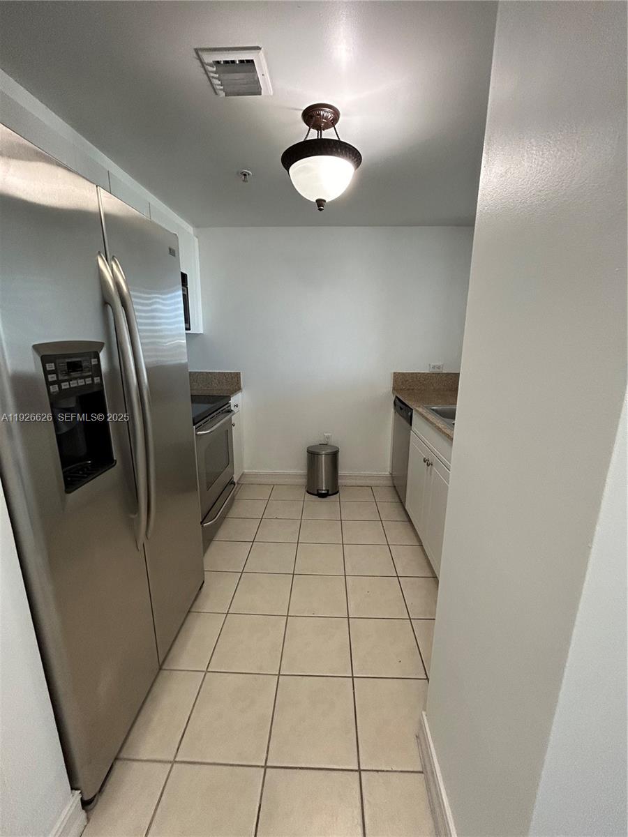 117 Northwest 42nd Avenue, Unit 1516 Miami, FL 33126 - Photo 26 of 76 a view of a refrigerator in kitchen and an empty room