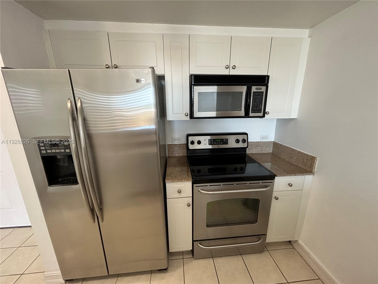 117 Northwest 42nd Avenue, Unit 1516 Miami, FL 33126 - Photo 27 of 76 a kitchen with white cabinets and stainless steel appliances