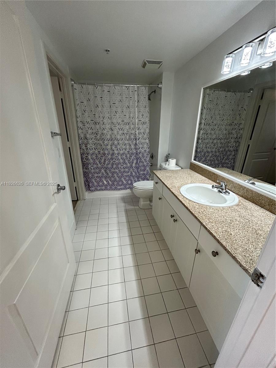 117 Northwest 42nd Avenue, Unit 1516 Miami, FL 33126 - Photo 42 of 76 a bathroom with a granite countertop sink a toilet and a mirror