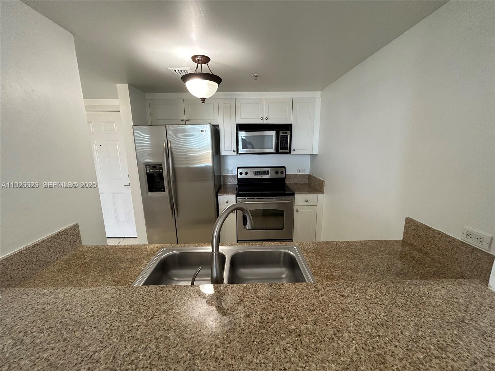 117 Northwest 42nd Avenue, Unit 1516 Miami, FL 33126 - Photo 44 of 76 a view of kitchen with refrigerator microwave and stove