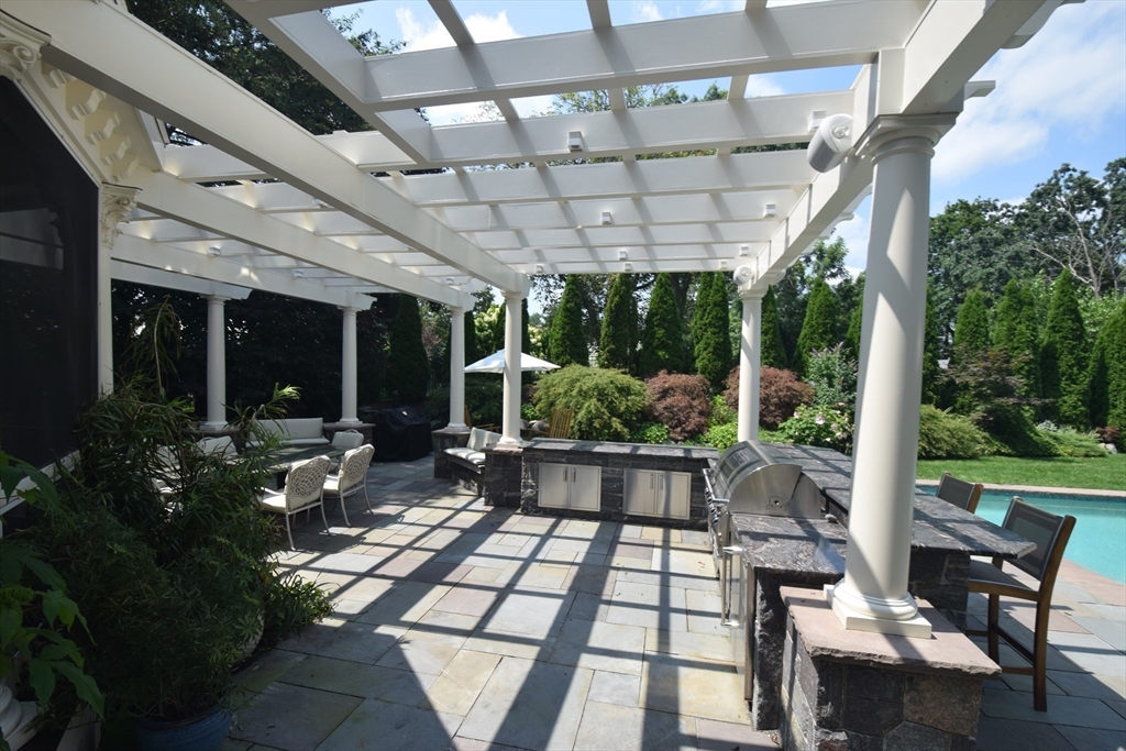 16 Meriam Street Lexington, MA 02420 - Photo 20 of 42 a view of a patio with table and chairs potted plants and floor to ceiling window