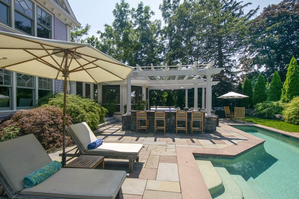 16 Meriam Street Lexington, MA 02420 - Photo 21 of 42 a view of a patio with couches table and chairs under an umbrella with a yard