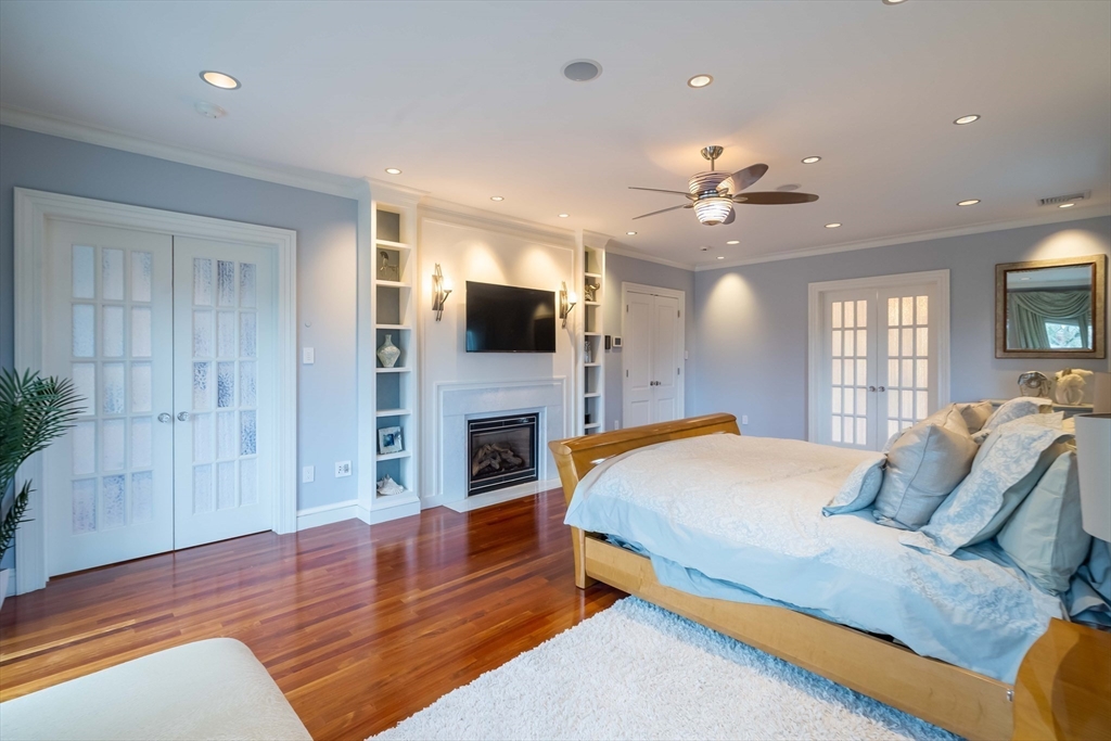 16 Meriam Street Lexington, MA 02420 - Photo 25 of 42 a spacious bedroom with a bed and a flat screen tv