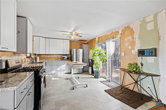 a kitchen with stainless steel appliances granite countertop a stove a sink and a refrigerator