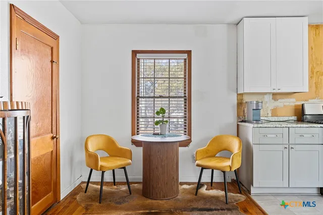 a view of a workspace with furniture and a window