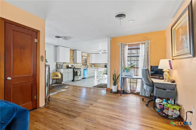 a living room with furniture and a wooden floor