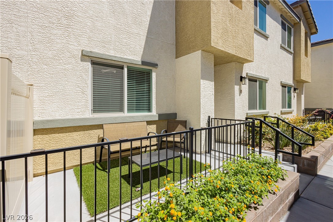 12369 Golden Wreath Road, Unit 2 Las Vegas, NV 89183 - Photo 18 of 19 A charming private patio features synthetic turf and an iron fence, perfect for intimate outdoor enjoyment.