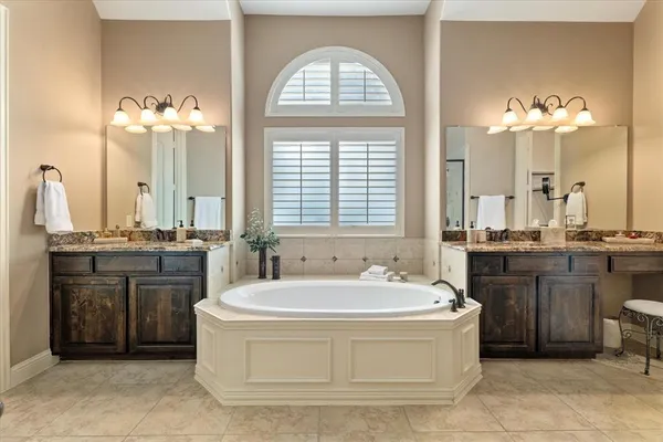 a spacious bathroom with a granite countertop tub sink and a mirror