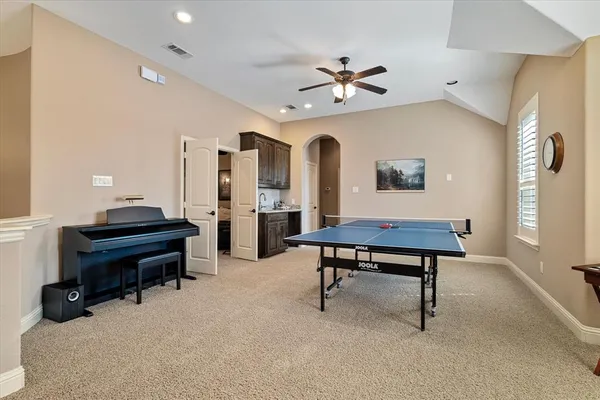 a living room with furniture a piano and a bookshelf