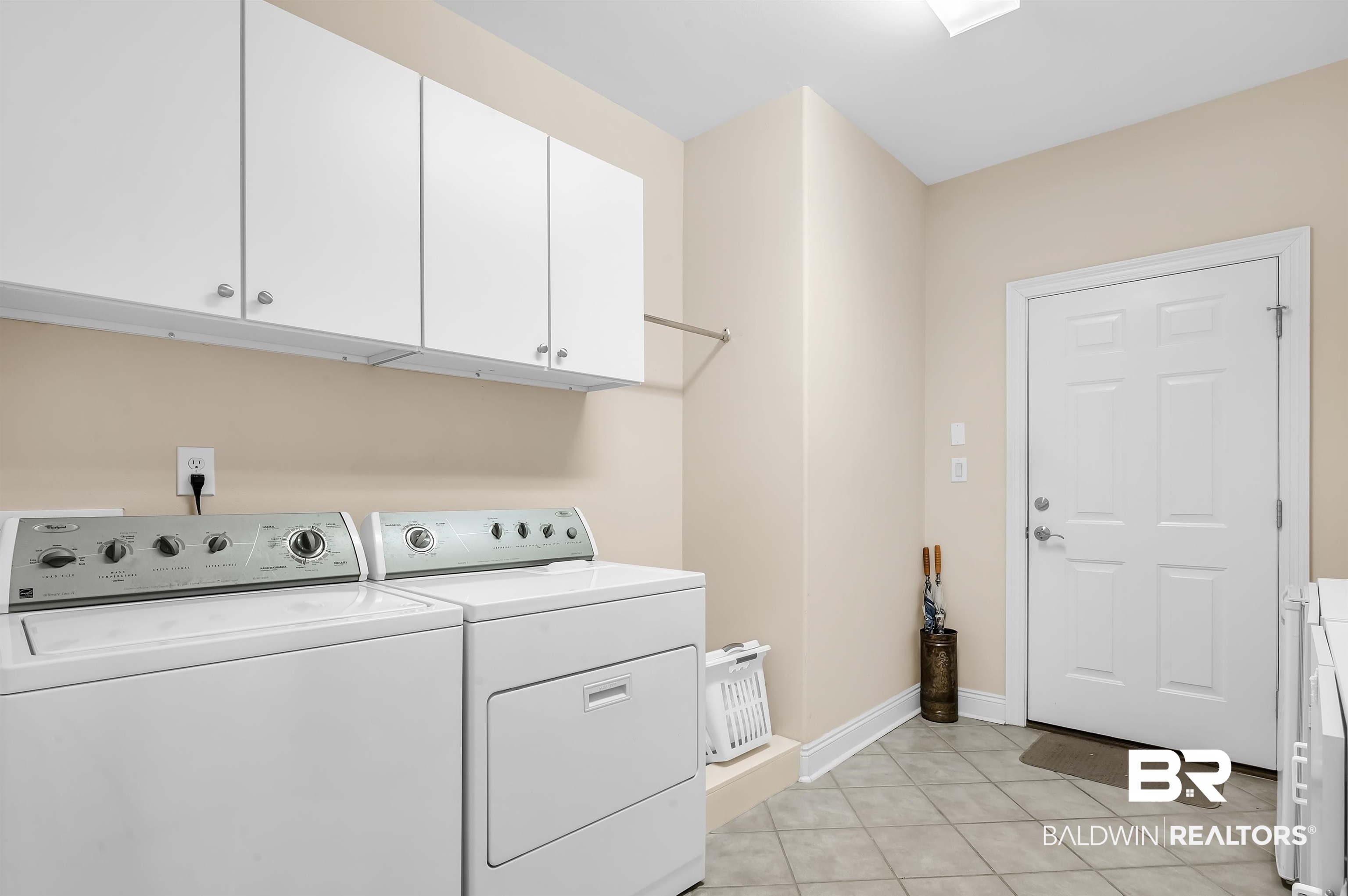 22739 Inverness Way Foley, AL 36535 - Photo 26 of 80 Laundry room with separate washer and dryer, cabinet space, light tile patterned flooring, and baseboards
