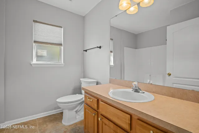 a bathroom with a sink toilet and a mirror
