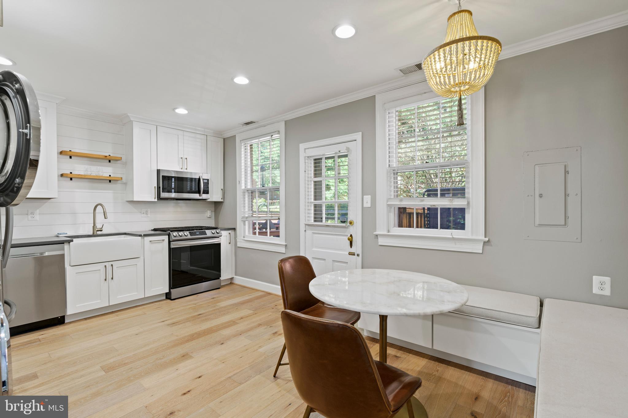 1300 South Cleveland Street, Unit 363 Arlington, VA 22204 - Photo 11 of 37 a kitchen with stainless steel appliances granite countertop a stove top oven a sink dishwasher a dining table and chairs with wooden floor