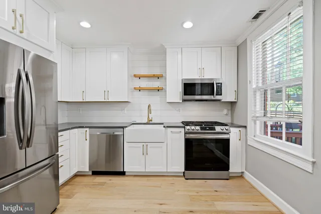 a kitchen with stainless steel appliances granite countertop a stove a refrigerator and a microwave