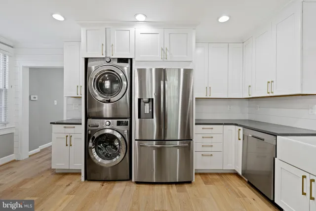 a kitchen with stainless steel appliances granite countertop a refrigerator and a stove top oven