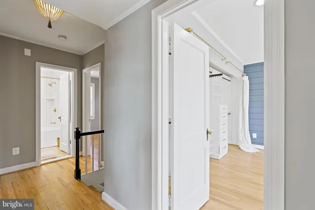 a view of a hallway with wooden floor and staircase
