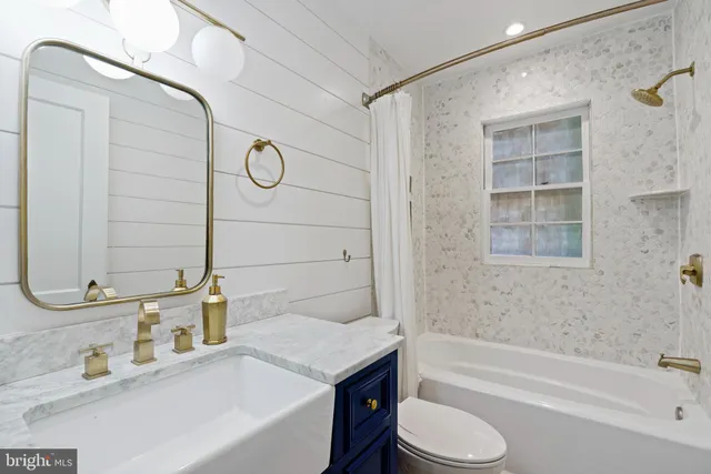 a bathroom with a granite countertop sink toilet and bathtub