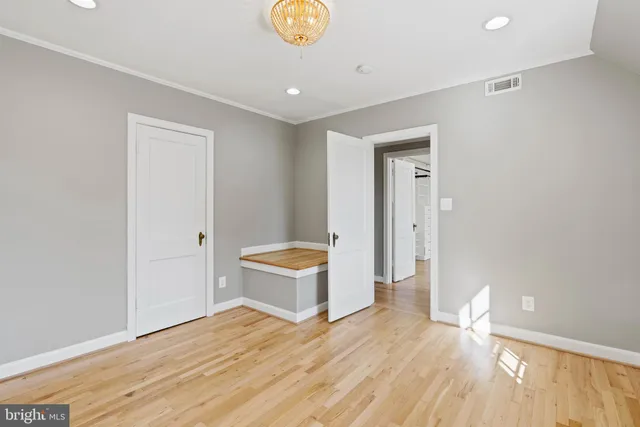 a view of empty room with wooden floor