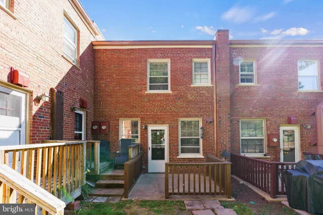 a view of a house with a small yard and wooden fence
