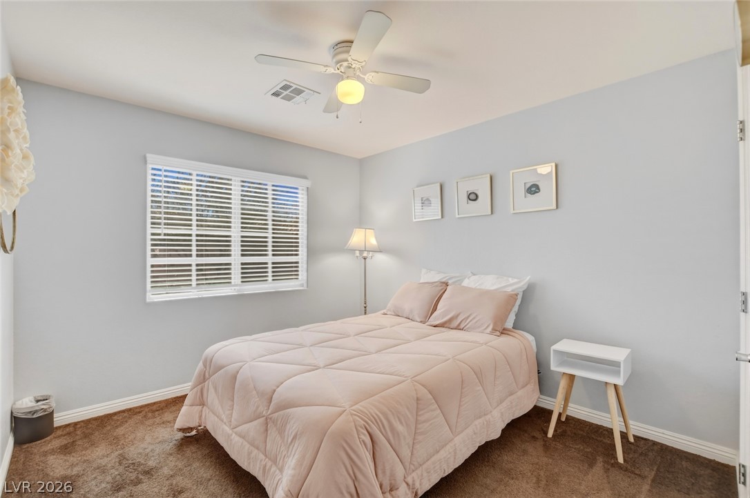 48 Jasmine Point Street Henderson, NV 89074 - Photo 47 of 62 Comfortable bedroom with soft carpet, natural illumination, and an overhead fan for cooling.
