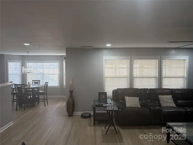 a living room with furniture a dining table and a window